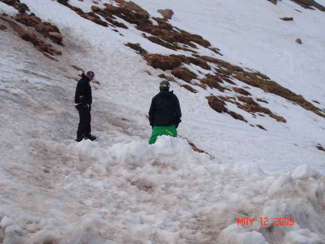 The two kids preparing to snowboard downhill